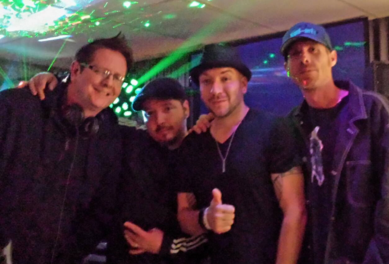 DJ Natural Nate® with four crew members under green laser lights at an event